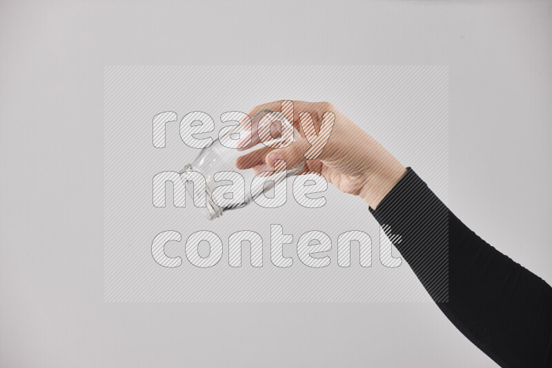 A woman in black abaya holding different glassware in different positions