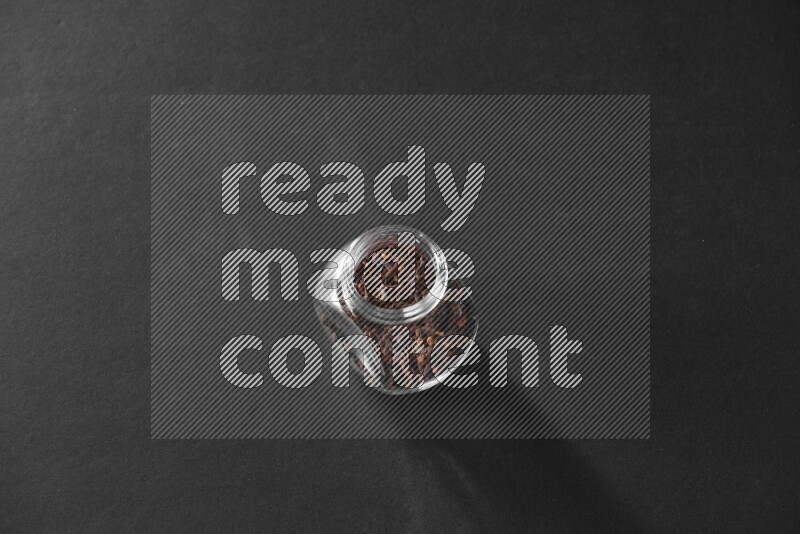 قرنفل في وعاء زجاجي علي خلفية سوداء