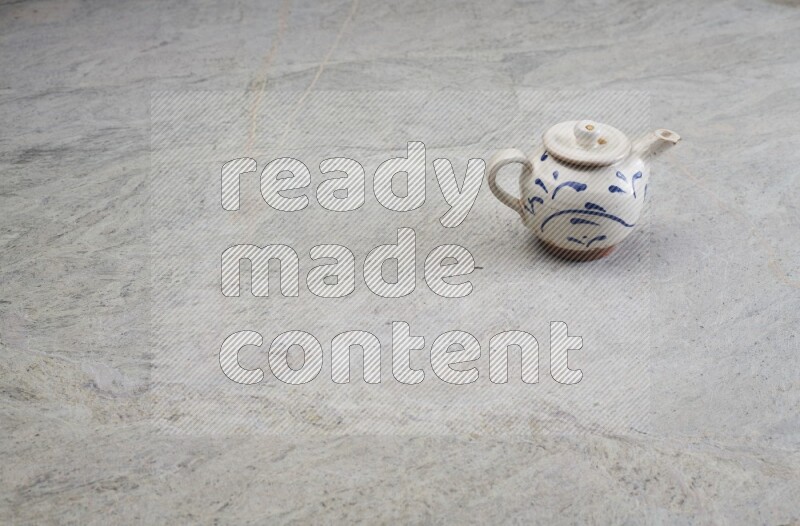 A pottery teapot on grey marble background