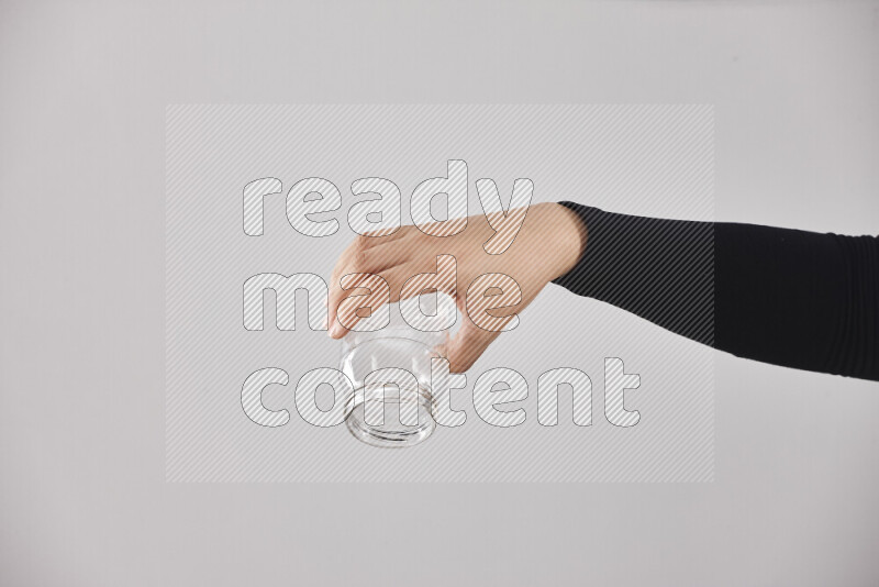 A woman in black abaya holding different glassware in different positions
