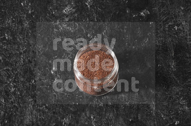 وعاء زجاجي ممتلئ ببذور حب الرشاد على أرضية سوداء