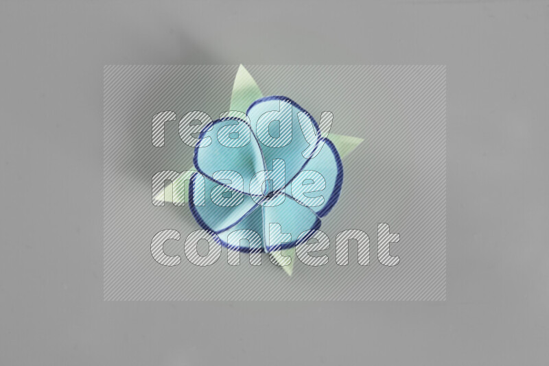 Origami flower on grey background