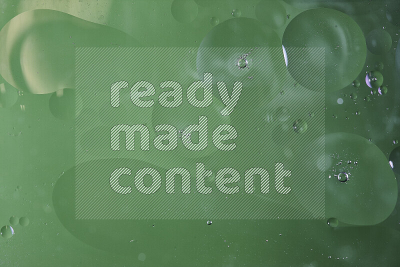 Close-ups of abstract oil bubbles on water surface in shades of green