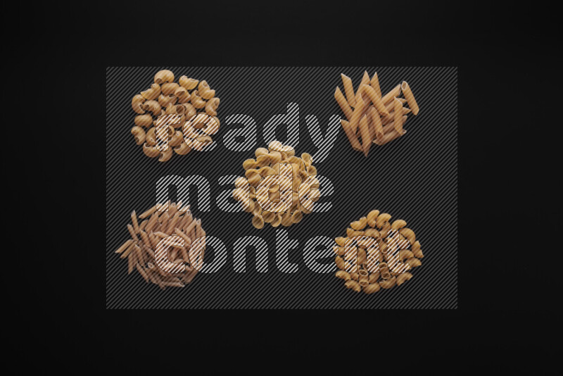 Different pasta types in bunches on black background