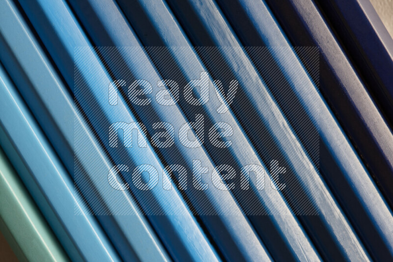 مجموعة من أقلام الرصاص الملونة مرتبة لتعرض تدرجا من الألوان الزرقاء علي خلفية رمادية