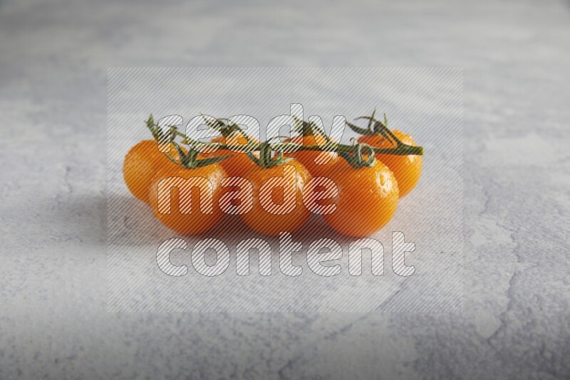 Orange cherry tomato vein on a light grey textured background 45 degree