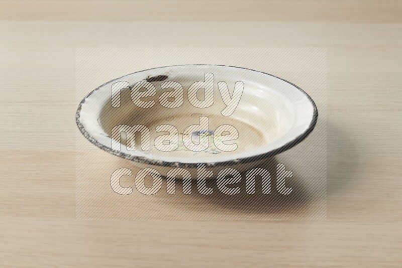 A vintage metal plate on light wooden background