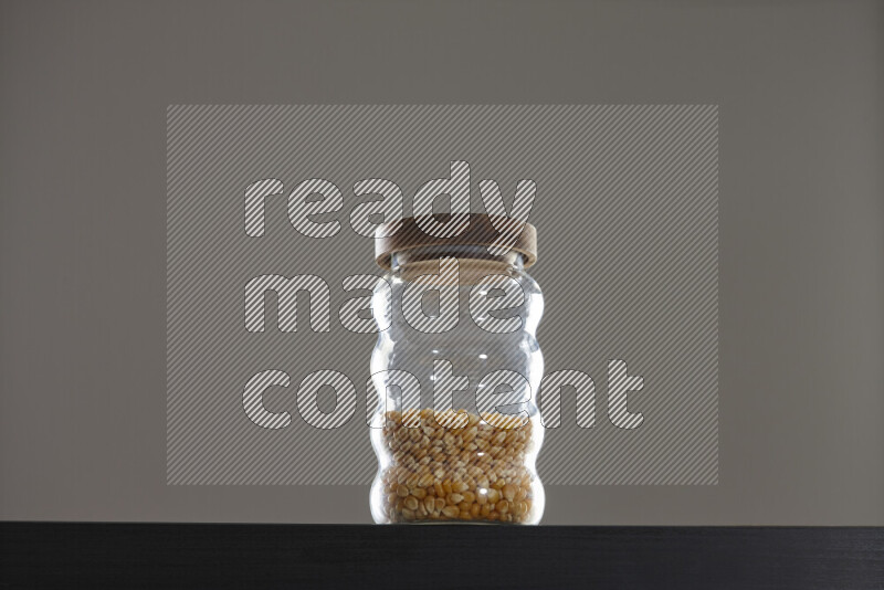 Pop corn in a glass jar on black background