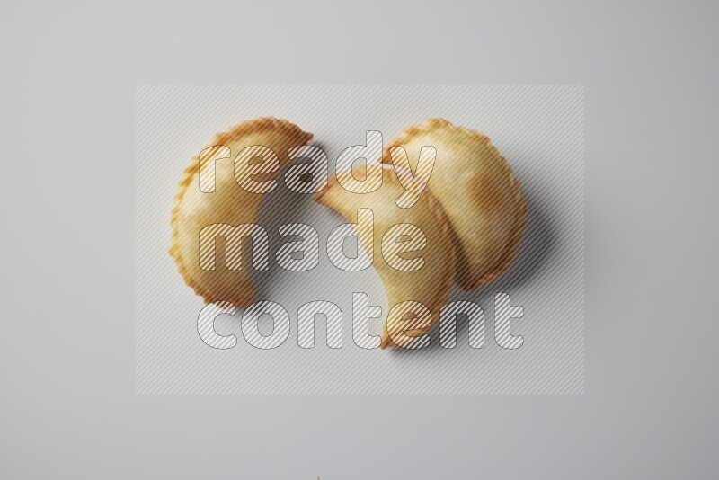 Three fried sambosa from a top angle on a white background