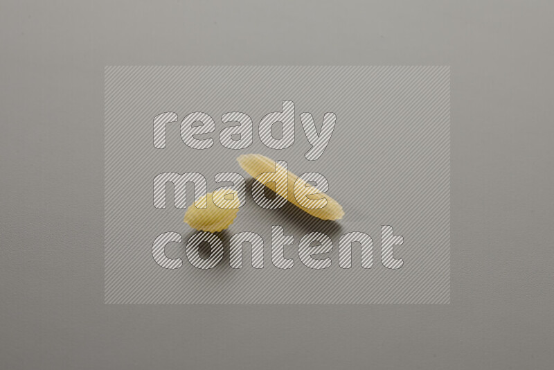 Shells pasta with other types of pasta on grey background