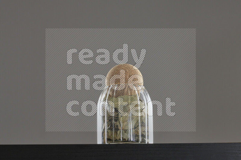 Bay laurel leaves in a glass jar on black background