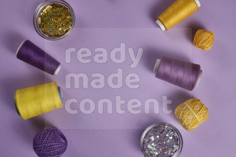 A yellow and purple collection of sewing and tailoring tools arranged on a purple background
