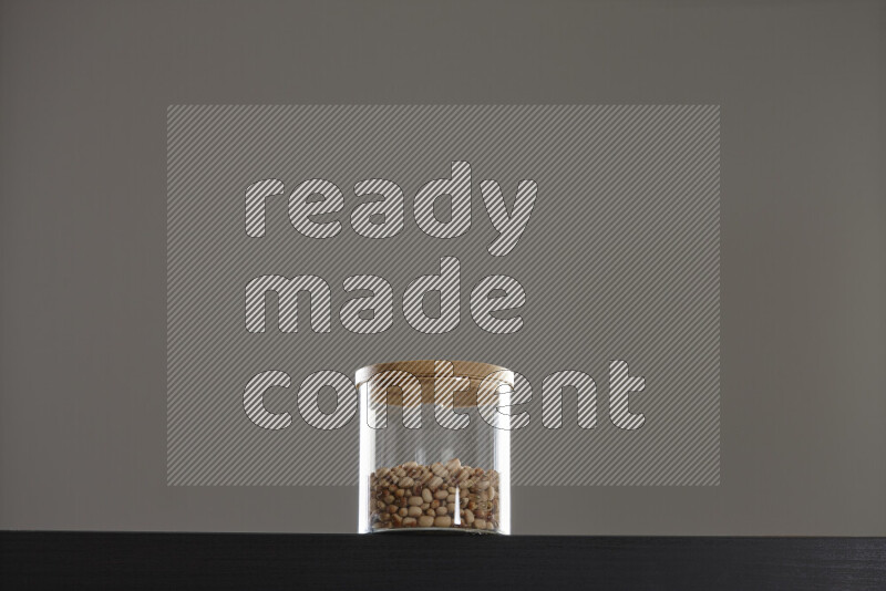 Black-eyed peas in a glass jar on black background