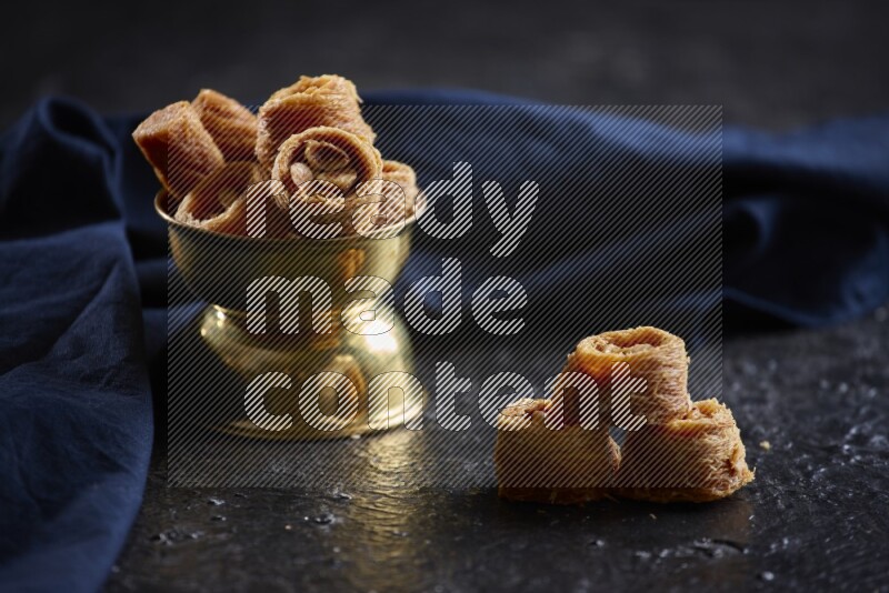 konafa in a metal bowl in a dark setup