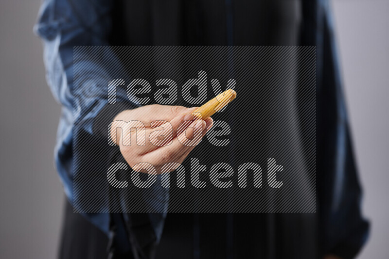 Woman in abaya holding different kinds of snacks in different positions