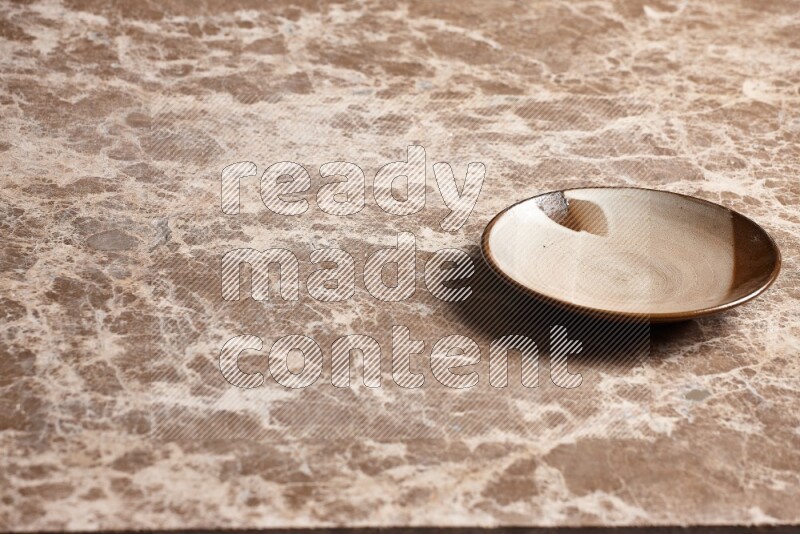 A multicolored pottery plate on beige marble background