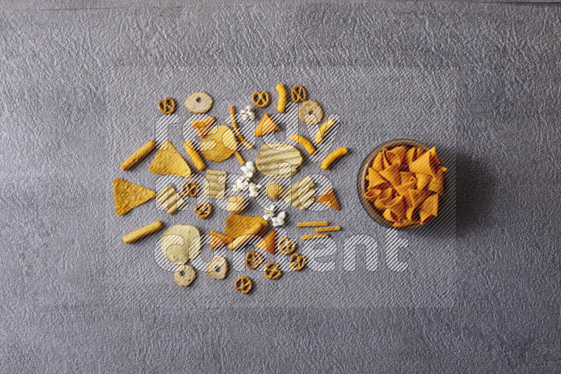 Assorted snacks in pottery bowls on grey background