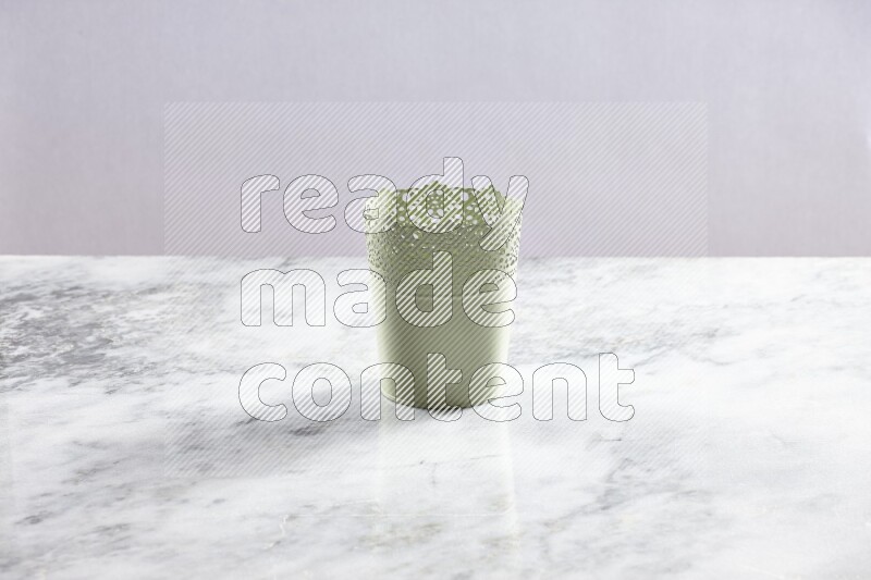 An empty green plant pot on grey marble background