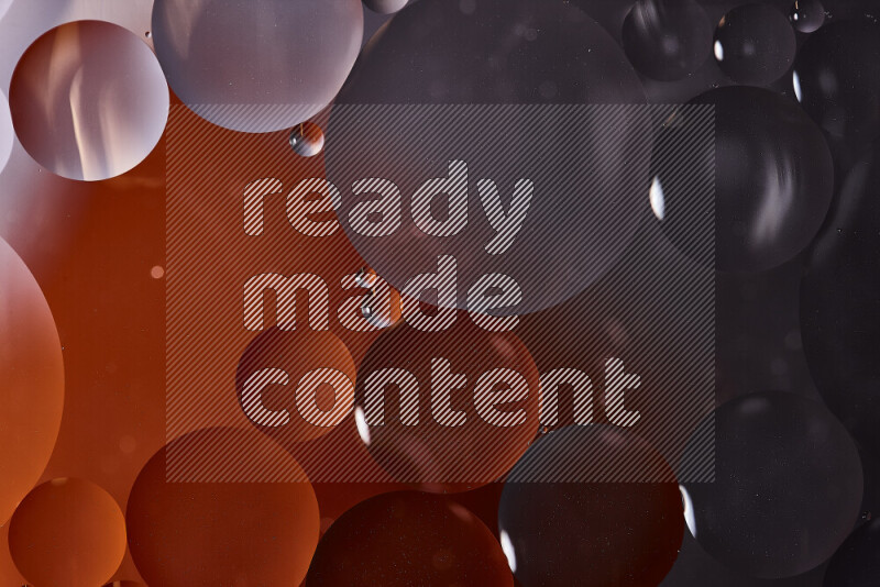 لقطات مقربة لفقاعات من الزيت على سطح الماء باللون الأسود والبرتقالي