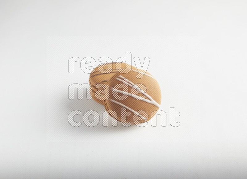 45º Shot of of two assorted Brown Irish Cream, and light brown  Almond Cream macarons on white background