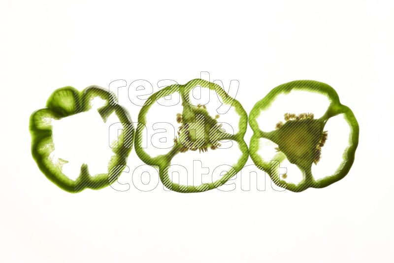 Green bell pepper slices on illuminated white background
