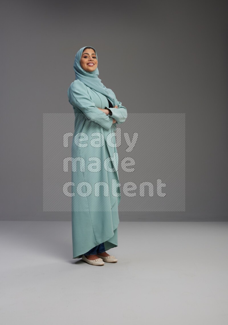 Saudi Woman wearing Abaya standing with crossed arms on Gray background