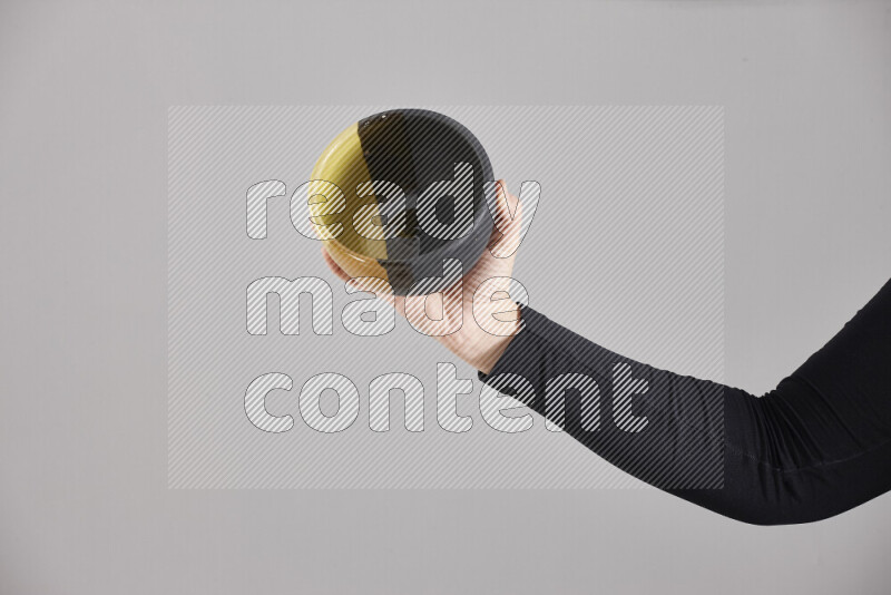 A woman in black abaya holding different pottery essentials in different positions