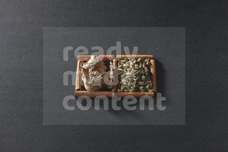 2 squares of cinnamon sticks full of cardamom and dried ginger on black flooring