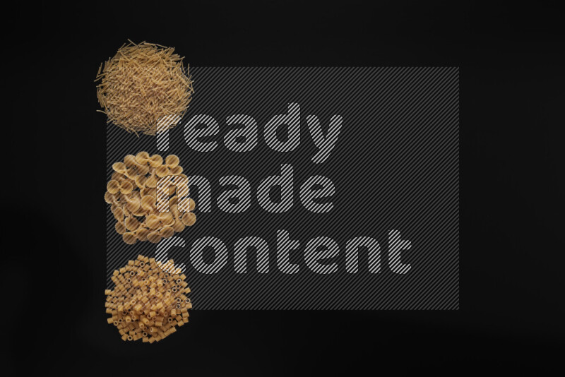 Different pasta types in 3 bunches on black background