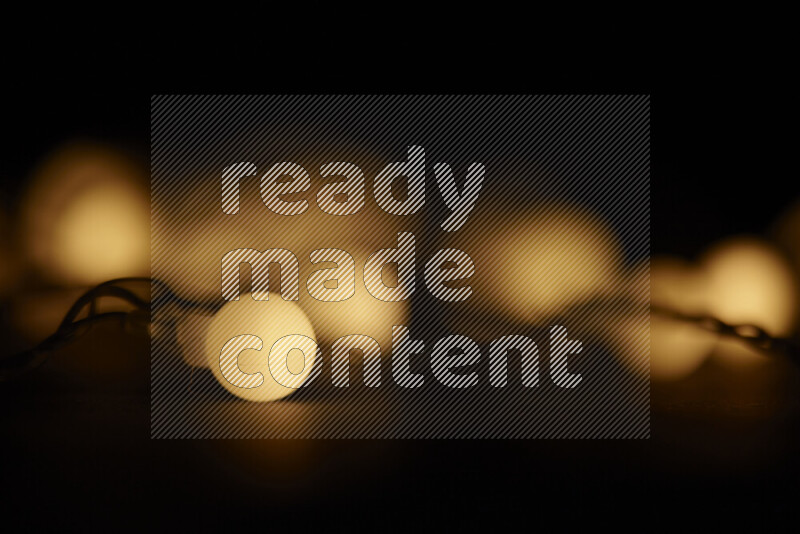 Light bulbs glowing against backdrop of golden bokeh