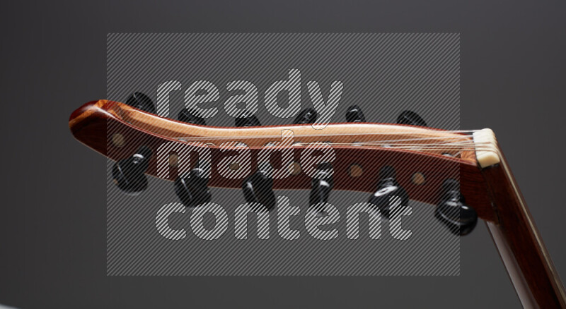 parts of a brown wooden Oud in a gray background