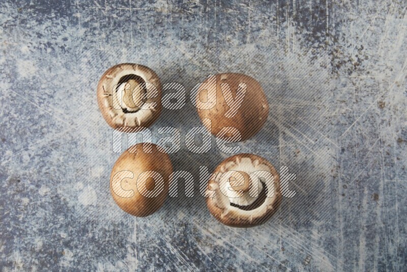 small fresh Cremini wood mushrooms topview on blue textured background