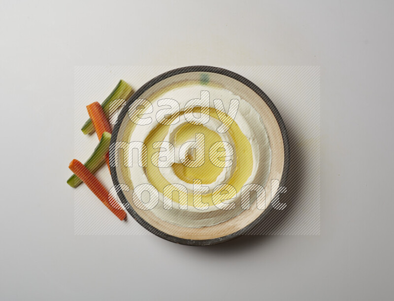 Lebnah garnished with olive oil in a pottery plate on a white background