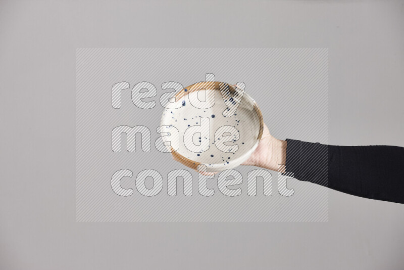 A woman in black abaya holding different pottery essentials in different positions