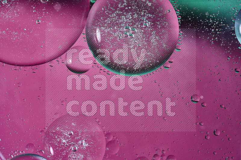 Close-ups of abstract oil bubbles on water surface in shades of green and pink