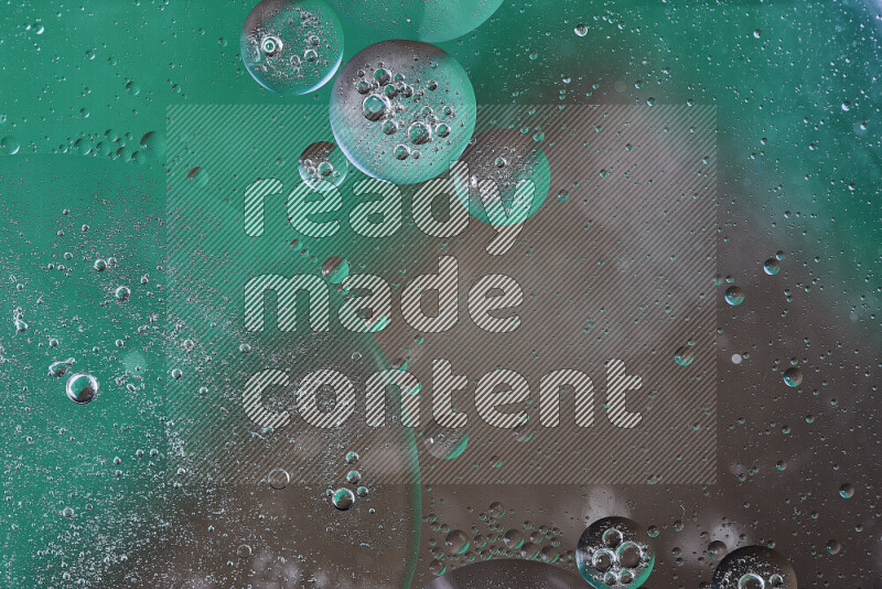 Close-ups of abstract oil bubbles on water surface in shades of green and brown