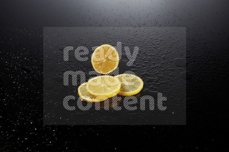 Lemon slices with water drops, and droplets on black background