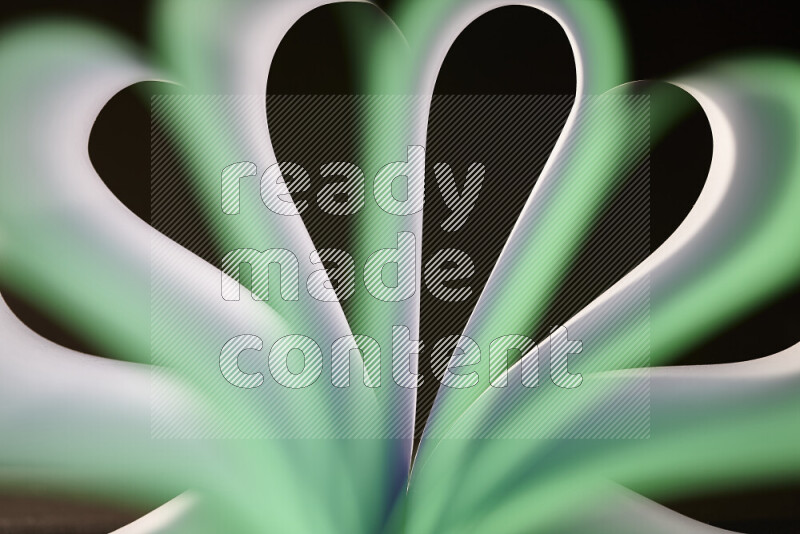 An abstract art piece displaying smooth curves in white and green gradients created by colored light