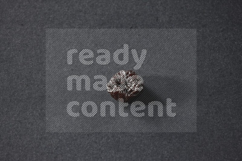 A dried plum on a black background in different angles