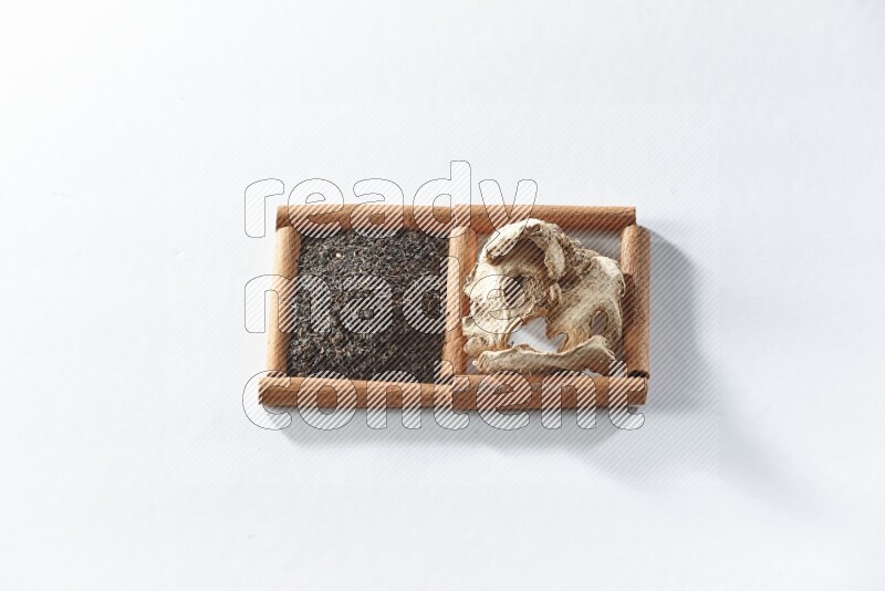 2 squares of cinnamon sticks full of black tea and dried ginger on white flooring