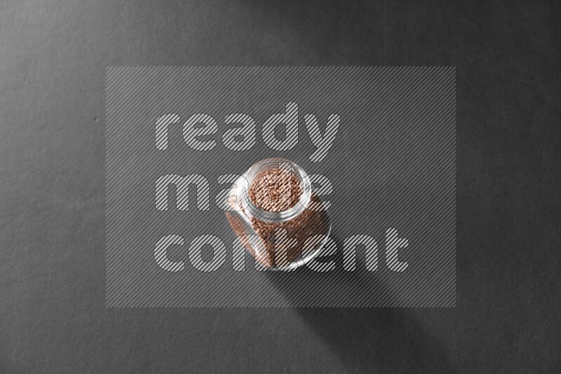 حبوب الكتان في وعاء زجاجي علي خلفية سوداء