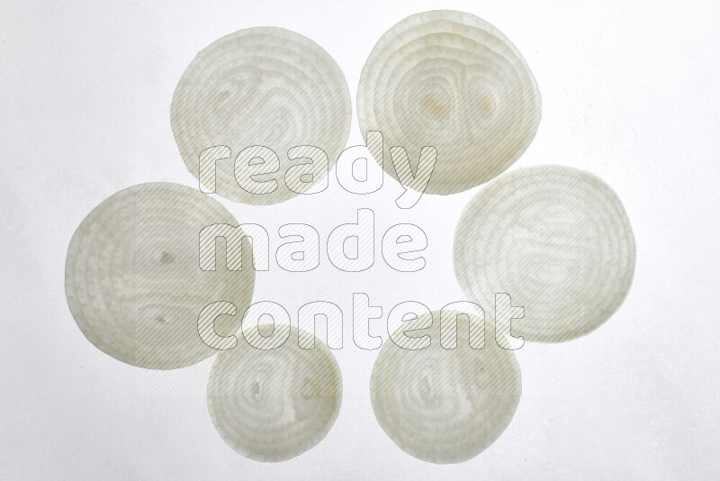 Onion slices on illuminated white background