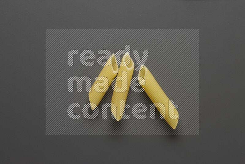 Penne pasta on grey background