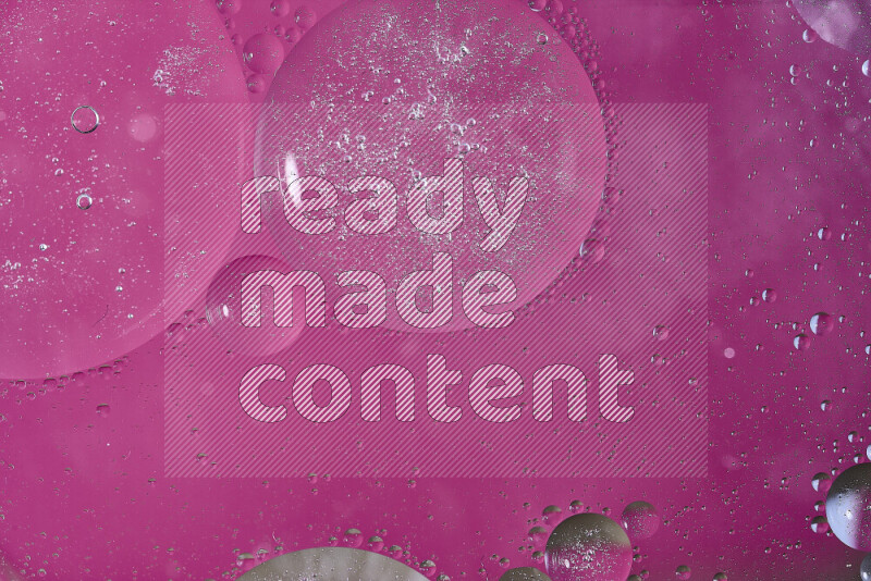 Close-ups of abstract oil bubbles on water surface in shades of pink