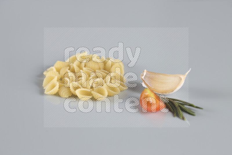 معكرونة مع مكونات متنوعة من الطماطم والثوم والبصل والفلفل الأحمر والفلفل الأسود والفلفل الأبيض وأوراق الغار وإكليل الجبل والهيل و مشروم على خلفية زرقاء فاتحة