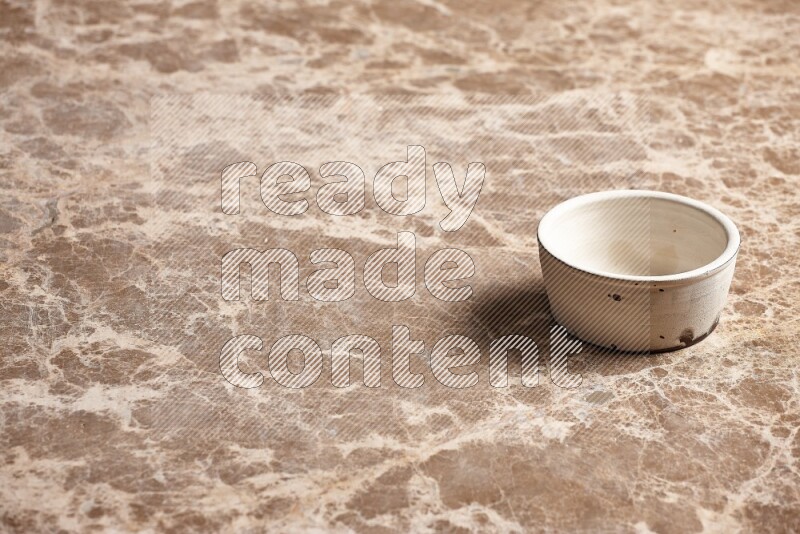 A white pottery bowl on beige marble background