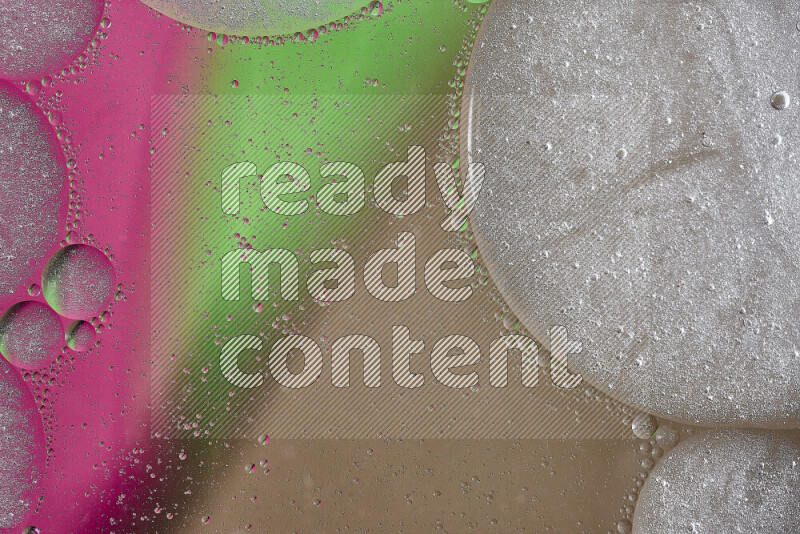 Close-ups of abstract oil bubbles on water surface in shades of brown, green and pink