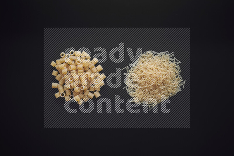 Different pasta types in bunches on black background