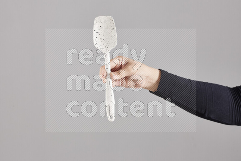 A woman in black abaya holding different wooden essentials in different positions