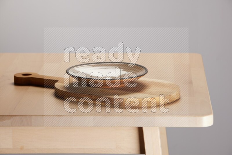 multi colored plate placed on a  wooden oval cutting board on the edge of wooden table